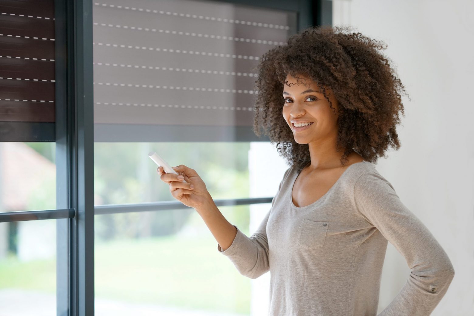 Woman at home controlling shutter opening